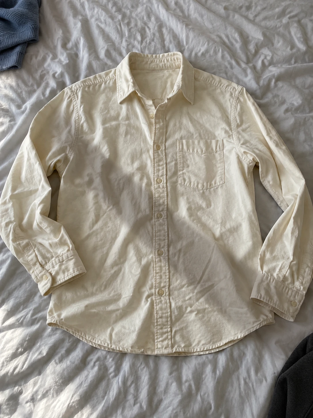 Original cream shirt with a cast shadow and other clothing at the corners